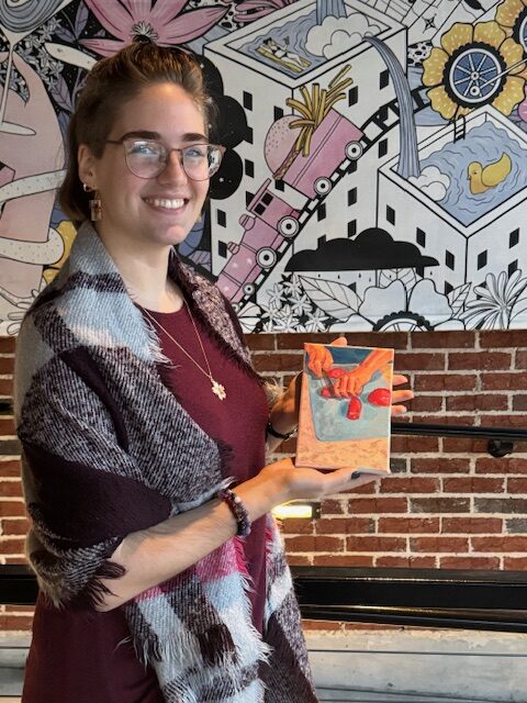 Painter holding small sold piece, copyright Grace Wright 2025